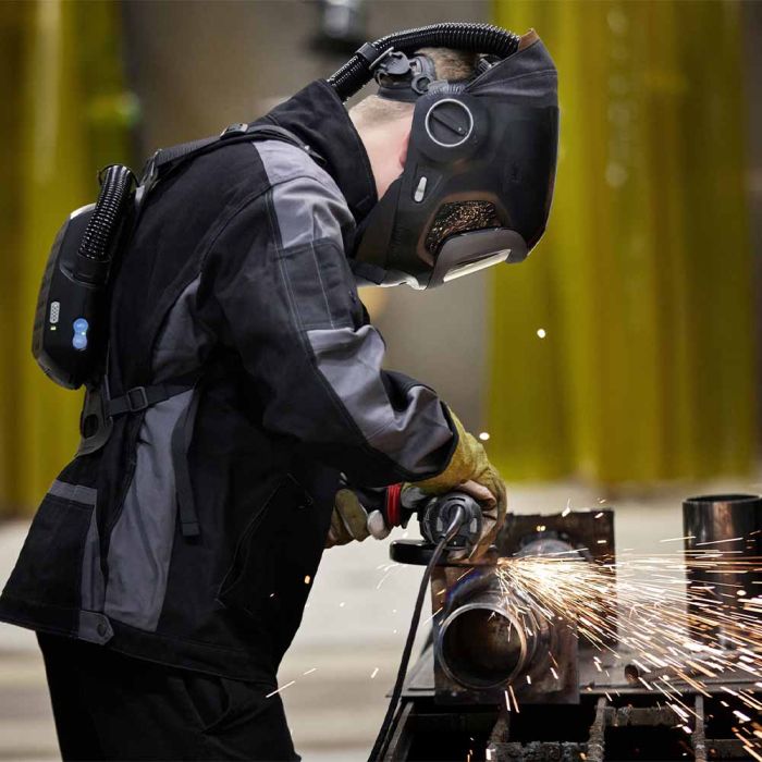 side view of a man welding wearing a 3M Speedglas G5-03NC Pro Air with Heavy-Duty Adflo PAPR