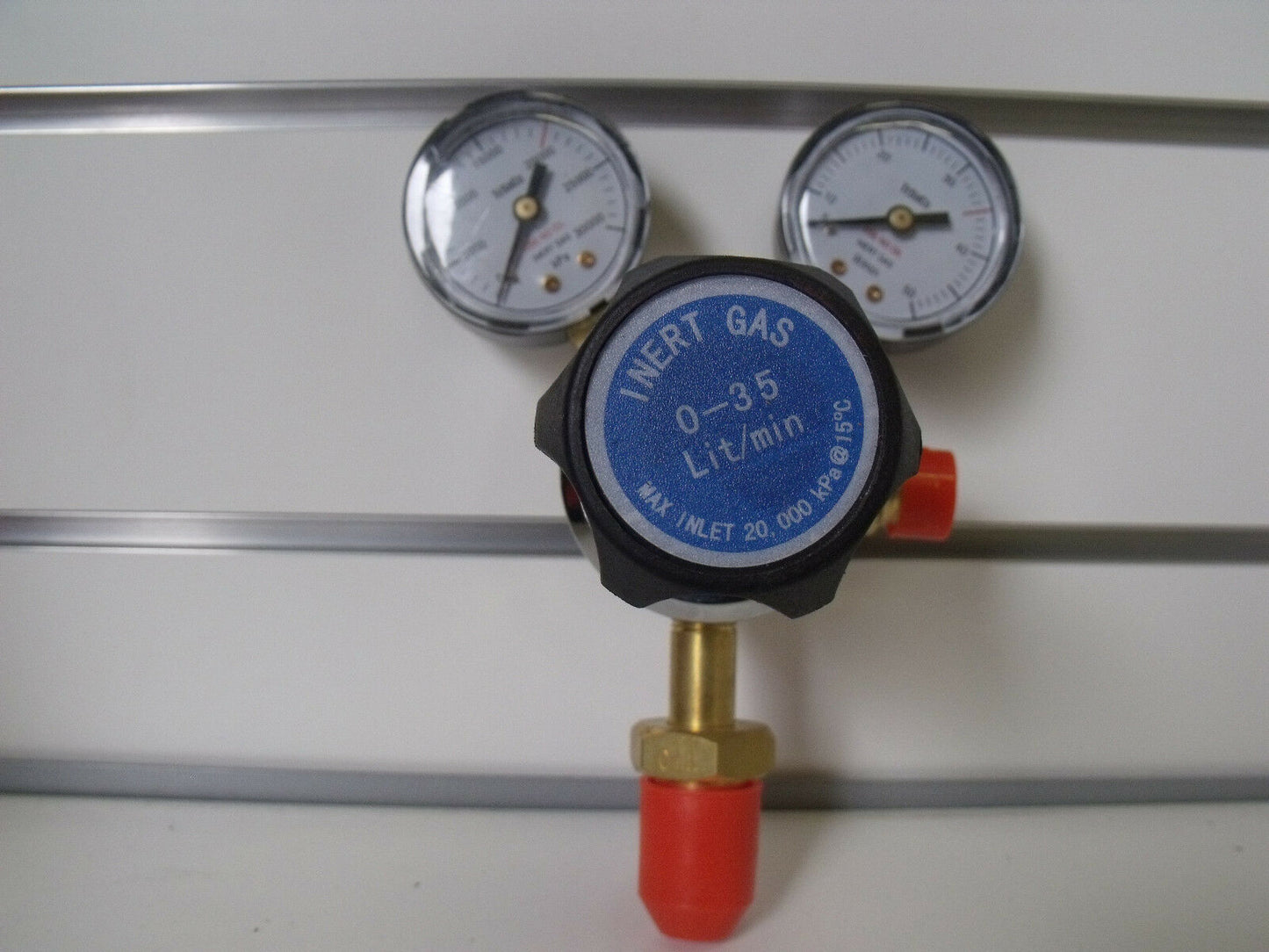 Argon regulator with pressure gauges, color-coded labels, and an ergonomic control knob, mounted on a white surface.