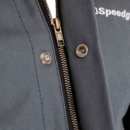 Close-up of a gray jacket with a zipper and Speedglas branding 